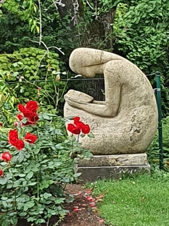 Statue eines lesenden Mädchens im Rosengarten von Mainz, von der Seite gesehen